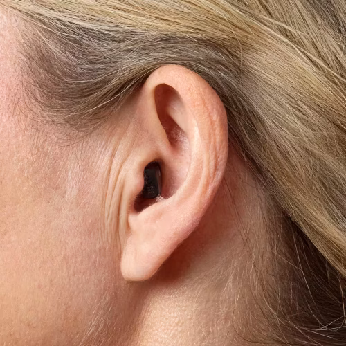 Mujer utilizando un audífono Oticon Zeal en el oído