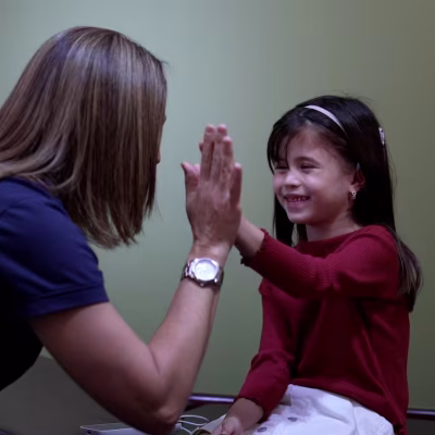 Profesional de Clínicas Para Oír Mejor durante una sesión de terapia auditiva con un paciente